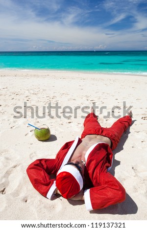Santa Claus on beach relaxing, enjoying summer