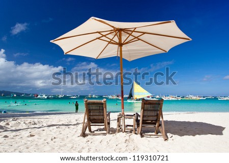 Sun umbrella with Sun Hat on chair longue  on tropical beach