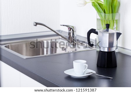 Coffeemaker And Cup Of Coffee In Kitchen Interior