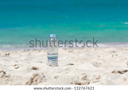 Drinking water in bottle on sand on beach