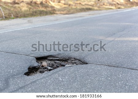 Bad road, big hole in street asphalt