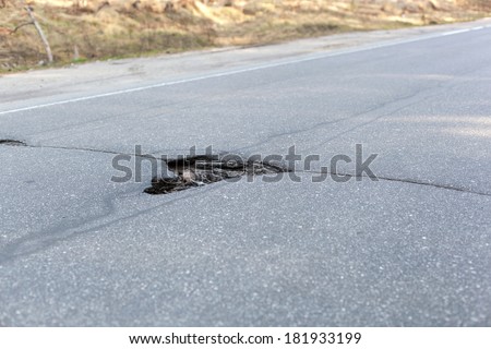 Bad road, big hole in street asphalt