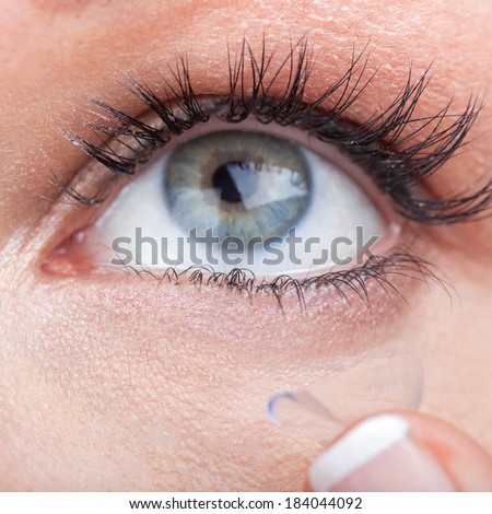 Woman eye with contact lens applying, macro