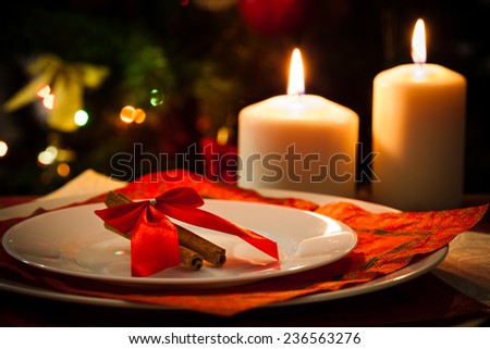 Christmas decoration, candles, cinnamon sticks and pieces of orange, on christmas tree background