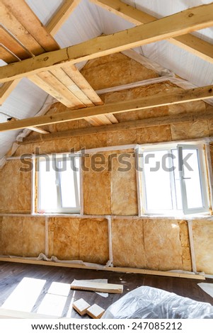 Inside wall heat isolation with mineral wool in wooden house,  building under construction