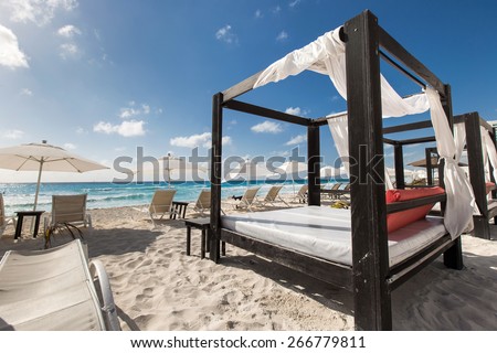 Luxury wooden lounge beds on a beautiful caribbean beach