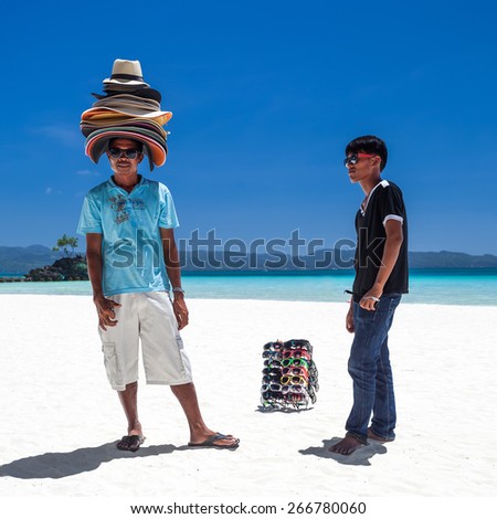 PHILIPPINES, BORACAY ISLAND - 20 MARCH 2013: Beach sellers of sunglasses and sun hats on coastline