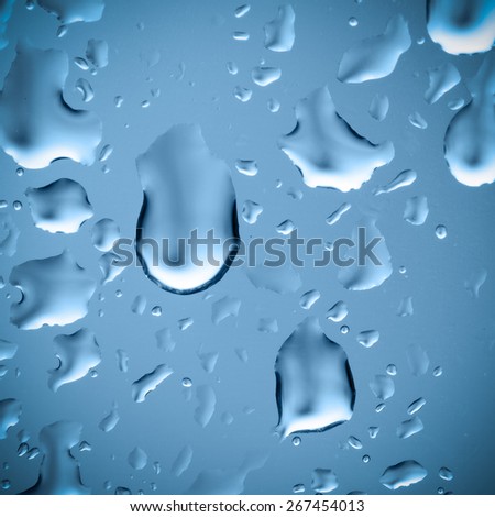 Raindrops on the window, abstract background. Blue tone