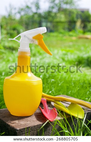 Gardening tools. Plastic watering can, mini shovel and fork on grass background