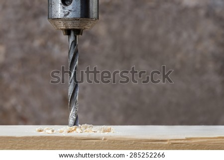 Drilling wooden plank with hand drill, closeup