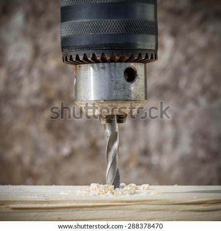 Drilling wooden plank with hand drill, closeup