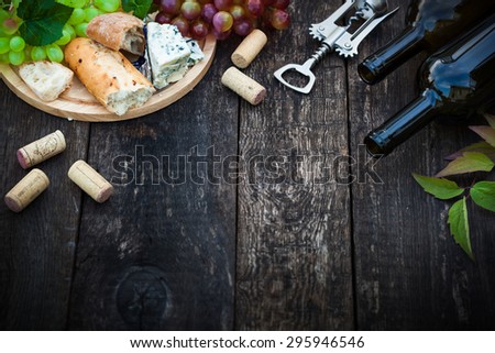 Wine bottles with grape leaves on wooden background with copy space, selective focus