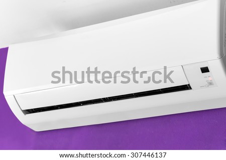 Split-system air conditioner on violet wall