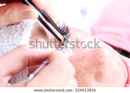 Lash making process, extreme long lashes and tweezers, woman eyelash extension