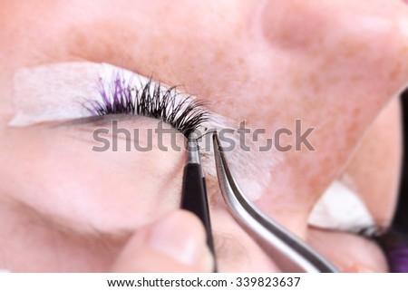 Lash making process, extreme long lashes and tweezers, woman eyelash extension
