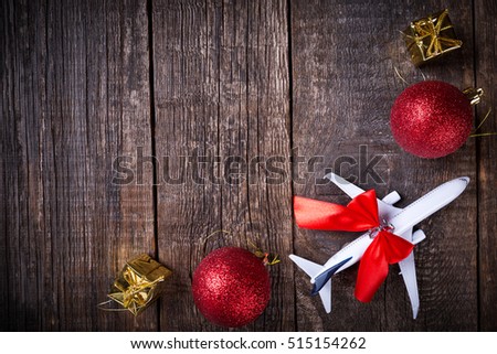 White blank model of passenger plane and christmas decoration toys on rustic wooden background. New Year celebration