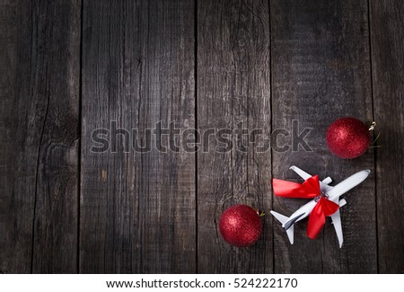 White blank model of passenger plane and christmas decoration toys on rustic wooden background. New Year celebration