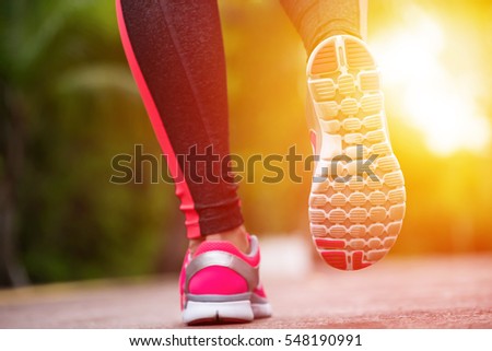 Fitness woman training and jogging in summer park, close up on running shoes. Healthy lifestyle and sport concept