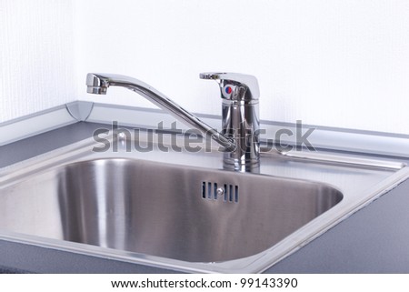 Water tap and sink in a modern kitchen, closeup