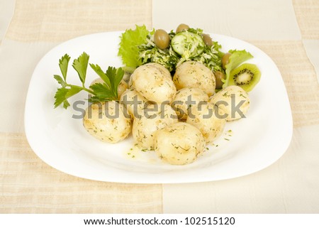 Early potatoes cooked with salad on the plate