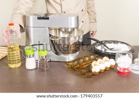 cook prepares dough for pancakes on a food processor