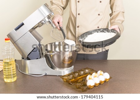 cook prepares dough for pancakes on a food processor