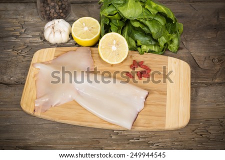 raw squid on a cutting Board on the table from the old boards