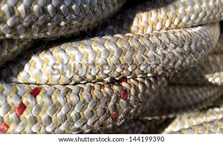 The texture of a close-up of twisted ship cords with red accents