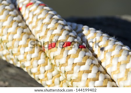 The texture of a close-up of twisted ship cord with red accents