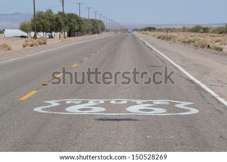 Route 66 sign on endless roads with yellow lines in Arizona desert , USA