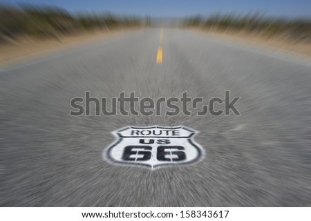 Route 66 pavement sign with Mojave desert - motion blur