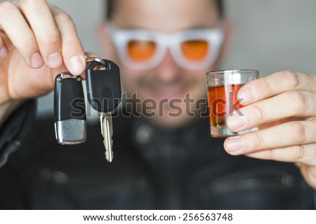 Alcoholic drink and car keys in hands - do not drink and drive concept