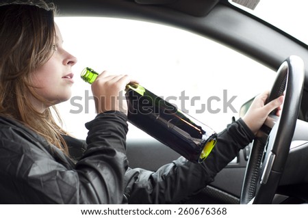 Close up portrait of a beautiful woman drinking alcohol while driving a car, do not drink and drive concept