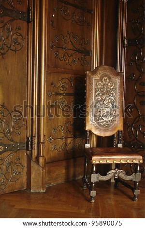 A beautiful old chair and wooden wall in a Royal Chamber in Czocha Castle, Poland