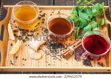 Three cups of tea with lemon, ginger, cinnamon and mint