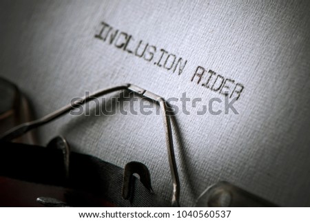 closeup of an old typewriter and the text inclusion rider typewritten with it in a paper, with a slight vignette added