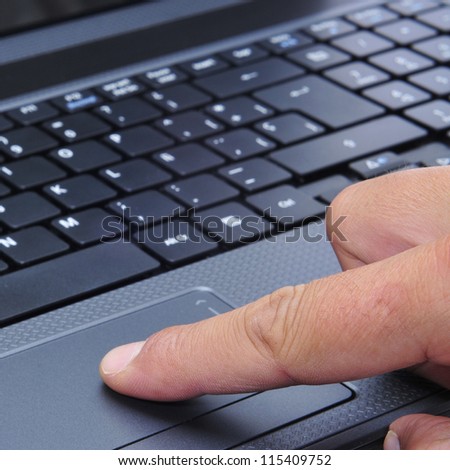 closeup of the hand of someone who is working with a laptop