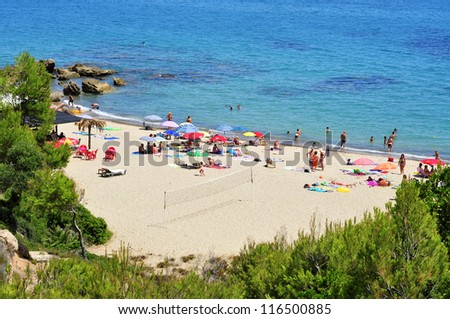 MONT-ROIG DEL CAMP, SPAIN - AUGUST 10: Vacationers in Cala dels Vienesos beach on August 10, 2012 in Miami Playa, Mont-roig del Camp, Spain. This small cove is 650 meters long and 25 wide