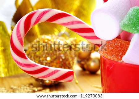 closeup of a pile of candies such as candy canes or marshmallows and some christmas ornaments