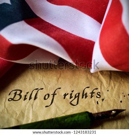 the text bill of rights written in an old piece of paper with a nib pen, and a flag of the united states,