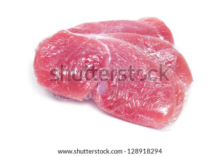 some slices of raw turkey meat wrapped in plastic wrap ready for freeze on a white background