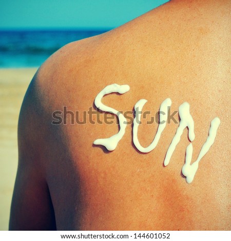 the word sun written with sunblock on the back of a man who is sunbathing on the beach, with a retro effect
