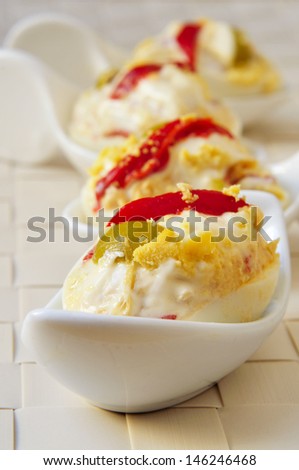 closeup of some spanish stuffed eggs served in porcelain spoons
