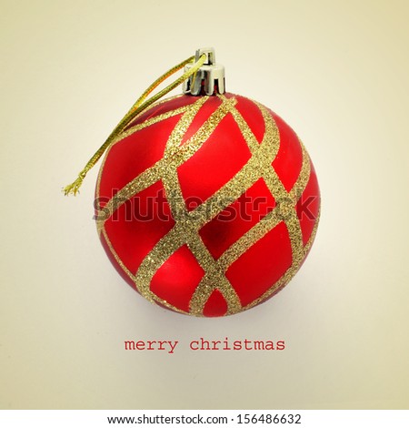 a red and golden christmas ball and the sentence merry christmas on a beige background, with a retro effect