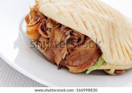 a doner kebab in a plate on a set table