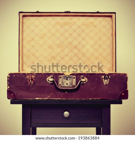 an open old suitcase on a table, with a retro effect