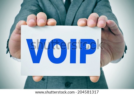 man wearing a suit holding a signboard with the text VOIP, Voice Over Internet Protocol, written in it