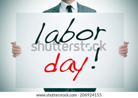 a man wearing a suit holding a signboard with the text labor day written in it