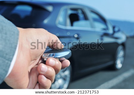 detail of a man in suit opening his car with the control remote key