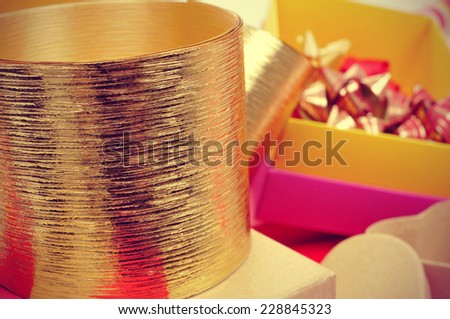golden ribbon, boxes and ribbon bows of different colors to prepare gifts, with a retro effect